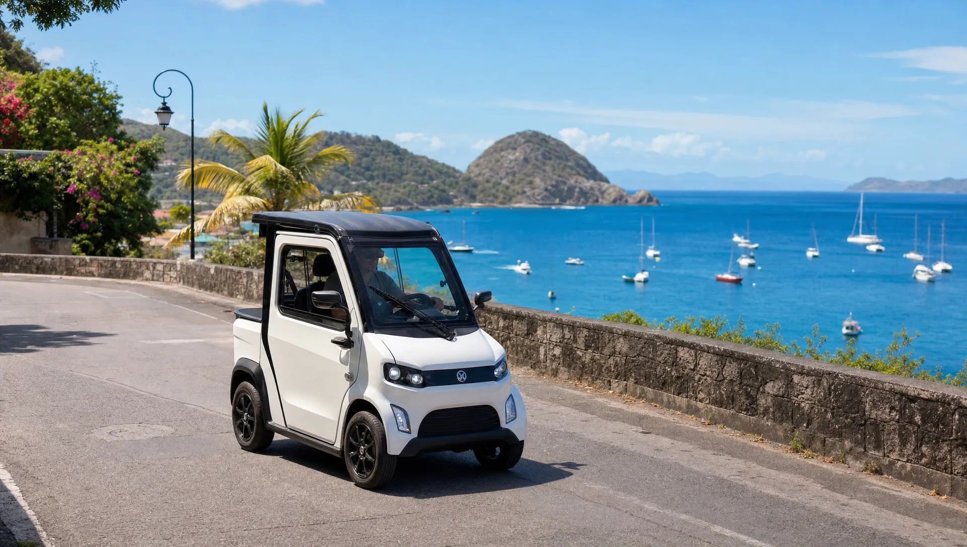 Une voiturette électrique circule sur une route de Terre-de-Haut avec la mer en arrière-plan, adaptée aux courts trajets aux Saintes.